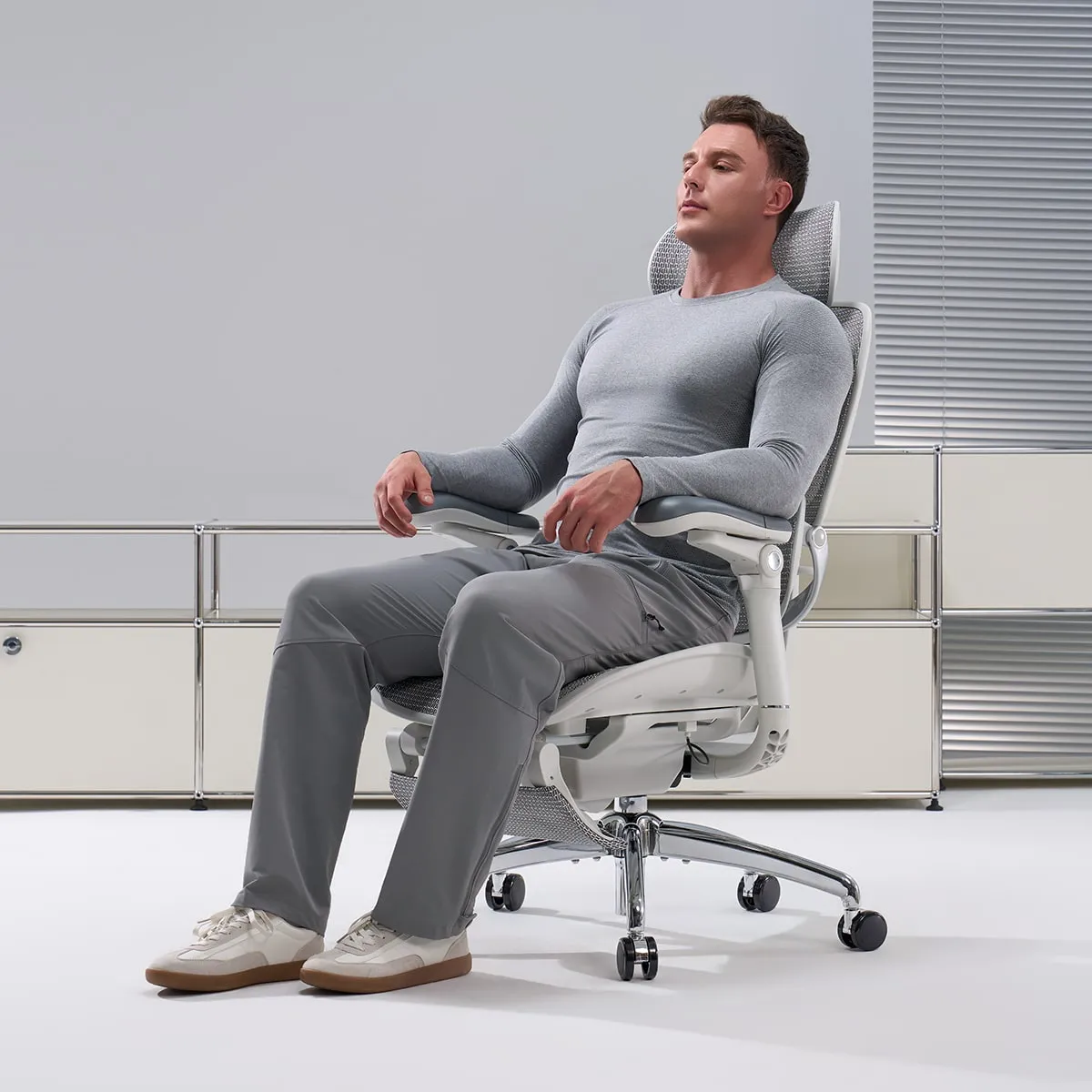 Un homme installé confortablement dans une chaise ergonomique Sihoo
