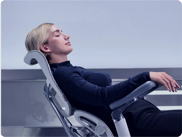 Femme inclinée sur une chaise Sihoo, les yeux fermés