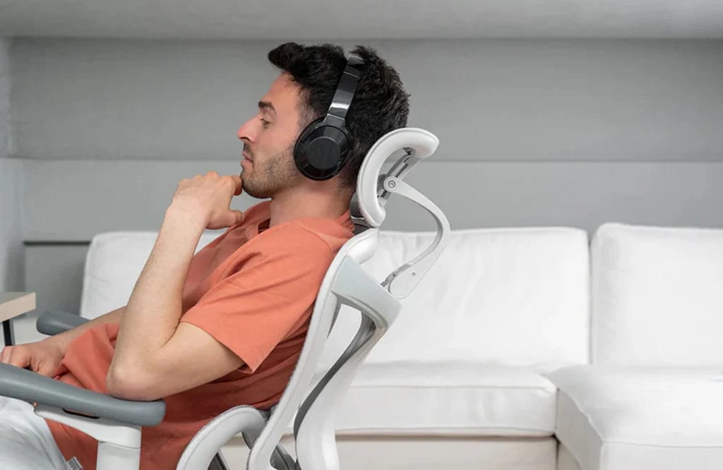 Un homme est assis sur une chaise ergonomique Sihoo