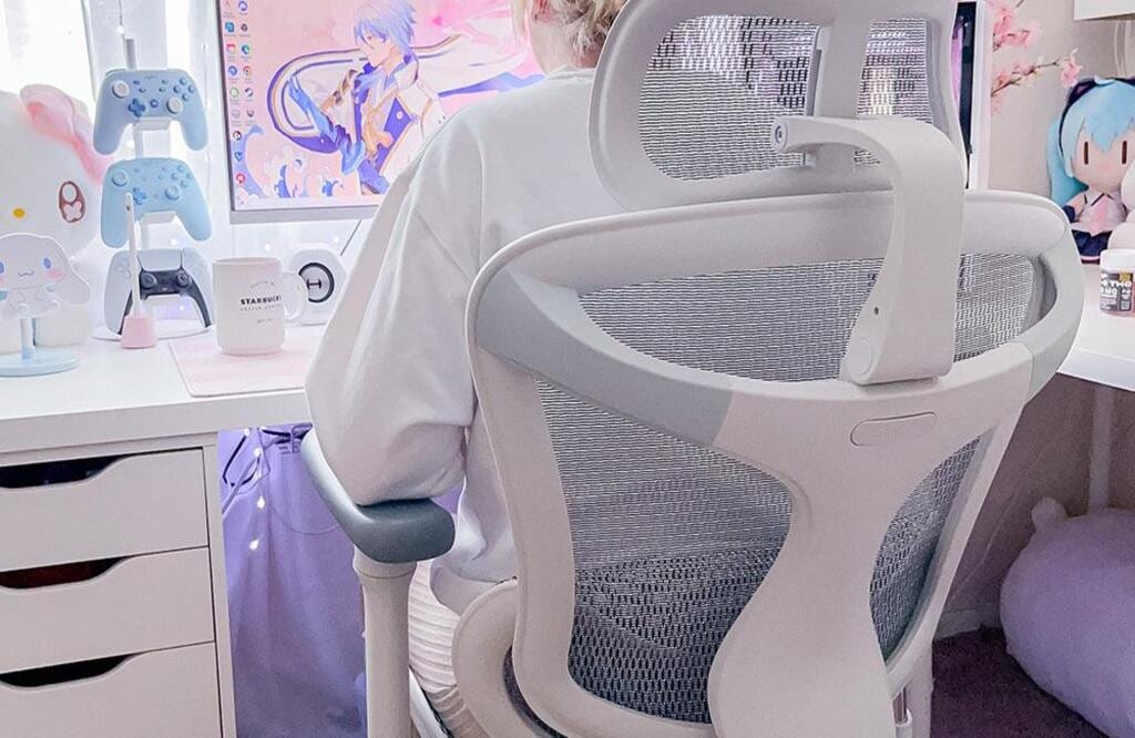 Télétravail sur chaise ergonomique blanche dossier mesh soutien lombaire
